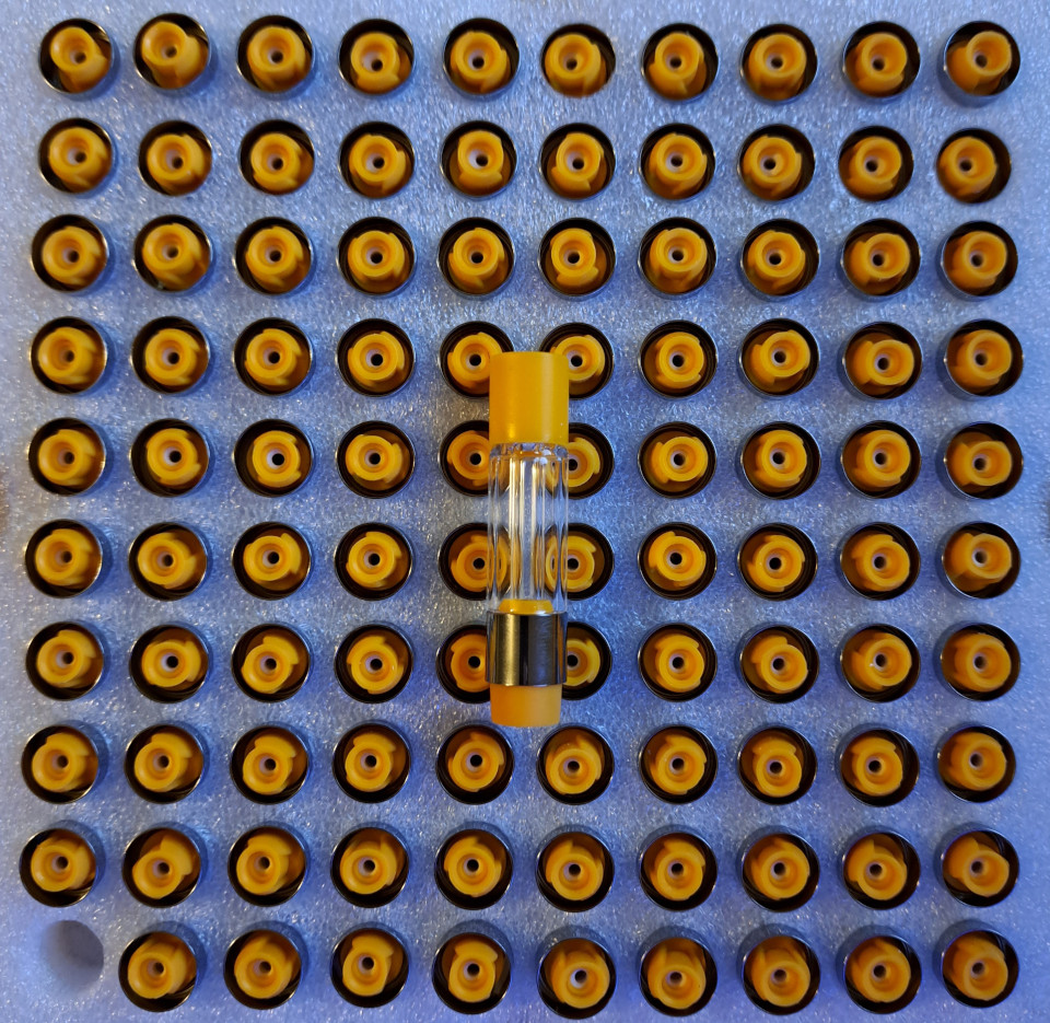 A row of yellow and black VG02 - 1ml - Full Glass vape cartridges.