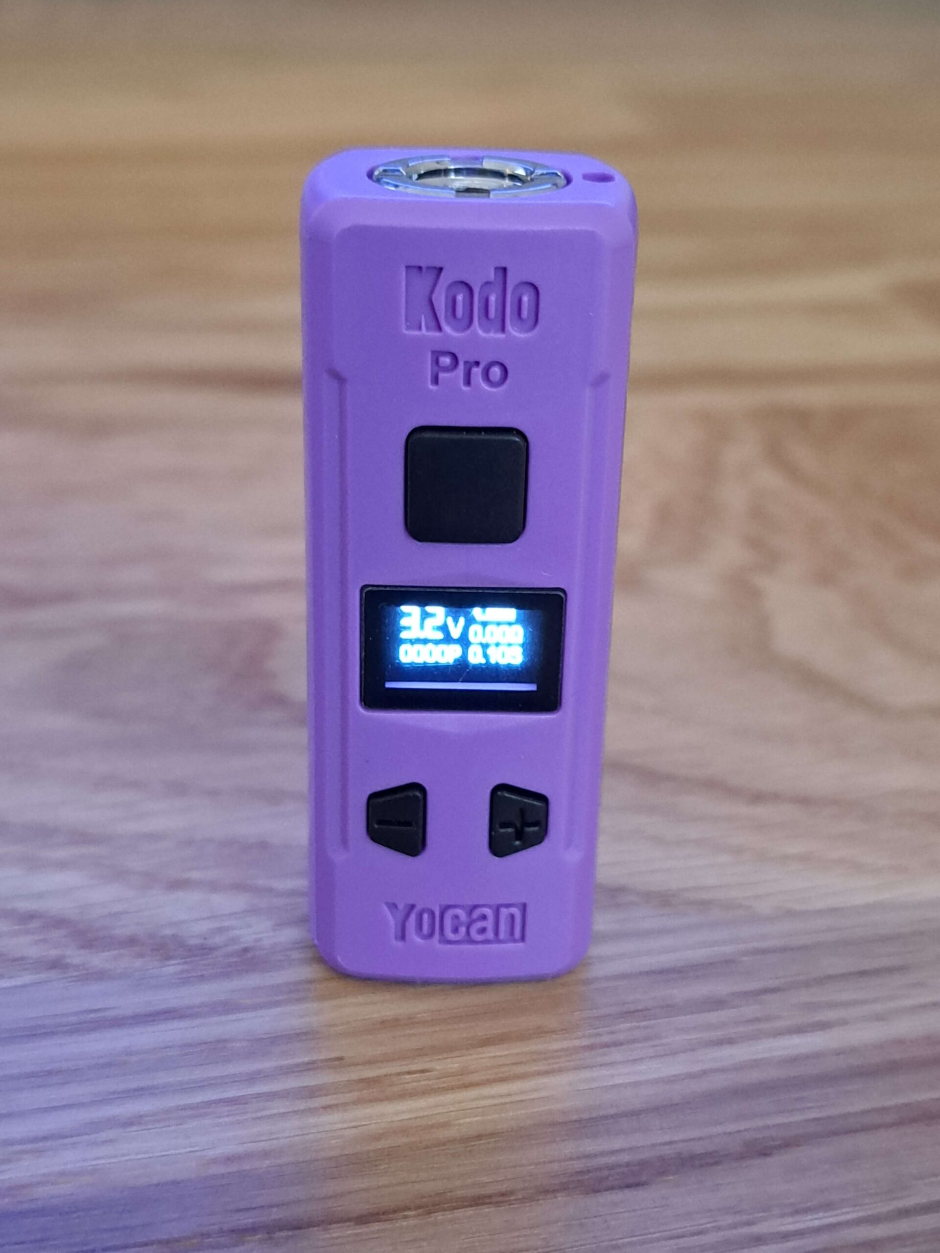 The Yocan Kodo Pro Battery is sitting on top of a wooden table.