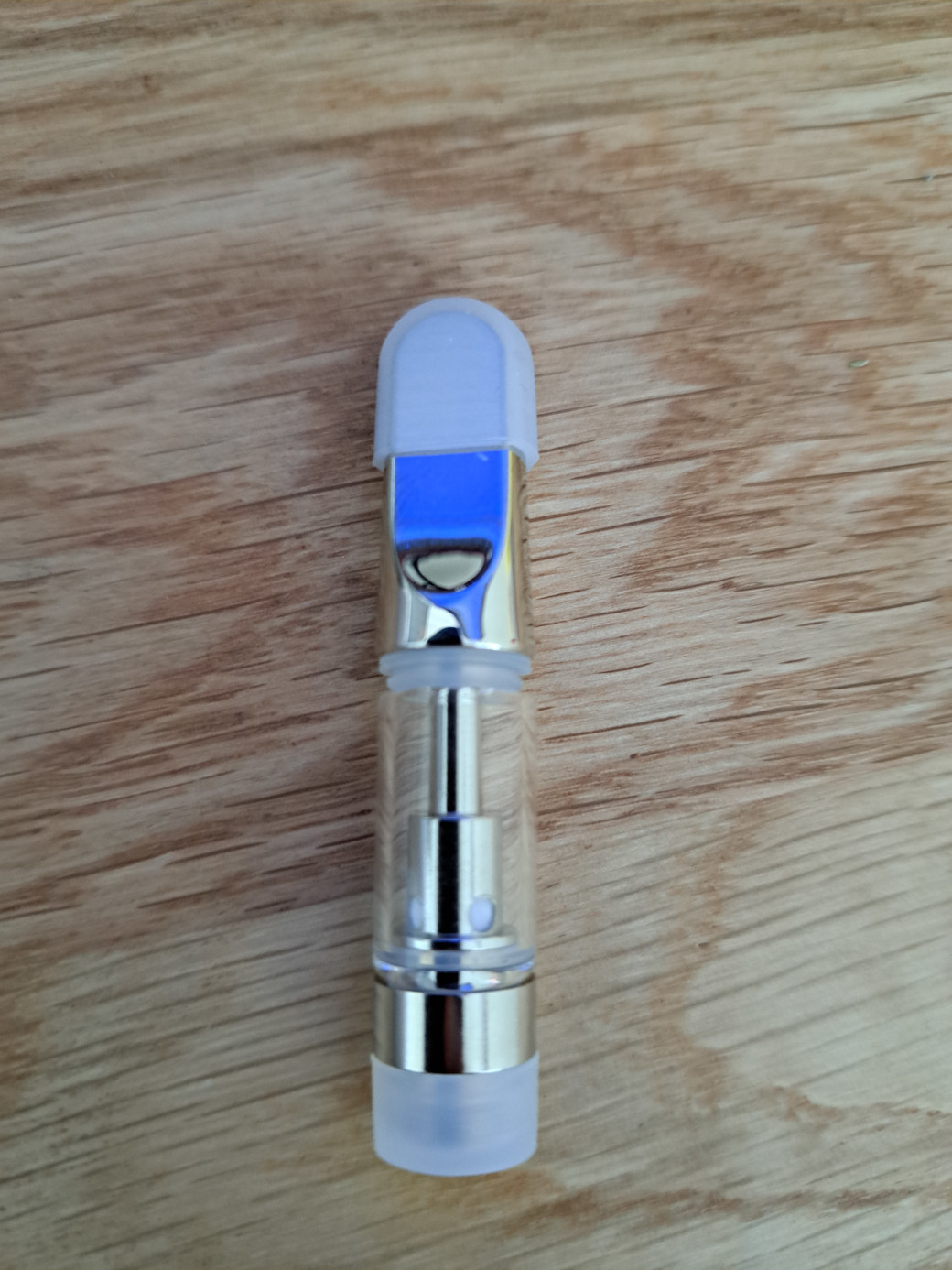 A small V4 - Metal Tip - 0.5ml bottle sitting on top of a wooden table.