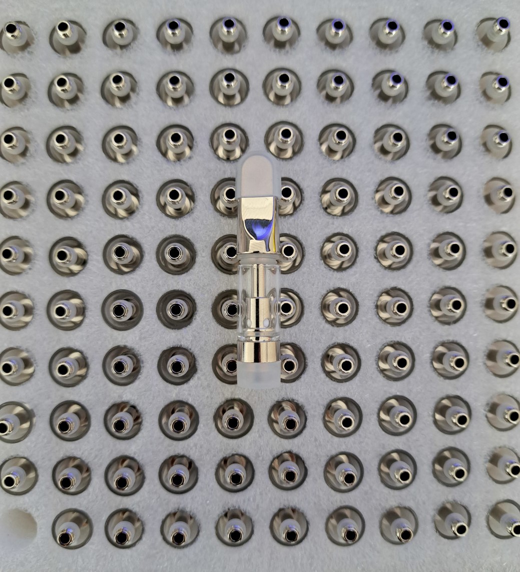 A group of small metal balls on a white plate, including V4 - Metal Tip - 0.5ml.
